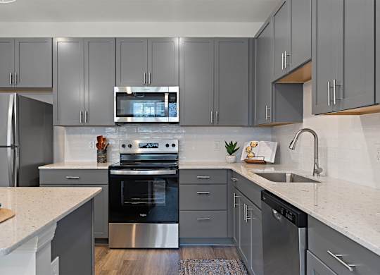 A modern kitchen with a stainless steel oven and microwave.