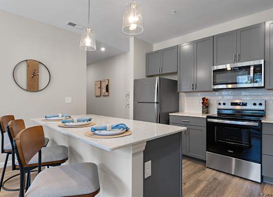 A kitchen with a white countertop and grey cabinets.