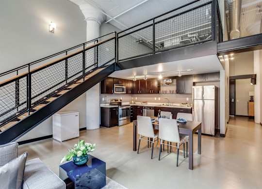 A modern open concept living space with a kitchen in the background.