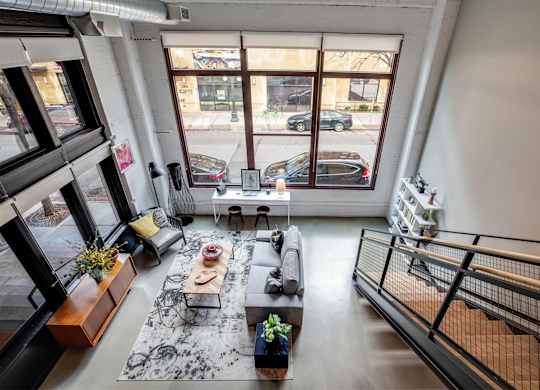 A living room with a black and white rug, a wooden coffee table, and a staircase.