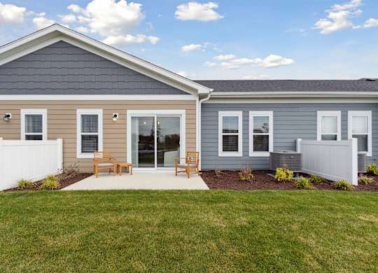 A house with a grey roof and a white fence.