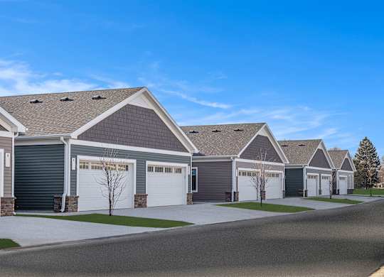 A row of houses with garages and driveways.