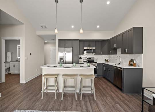 A modern kitchen with a center island and bar stools.