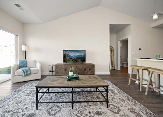 A living room with a couch, coffee table, and a painting on the wall.
