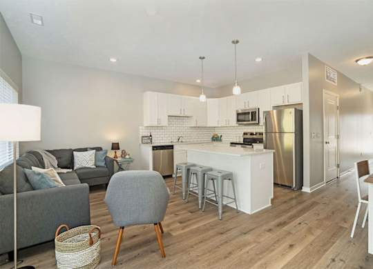 A modern kitchen with a grey chair in the middle of the room.