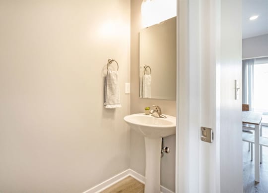 A white sink in a bathroom with a mirror above it.