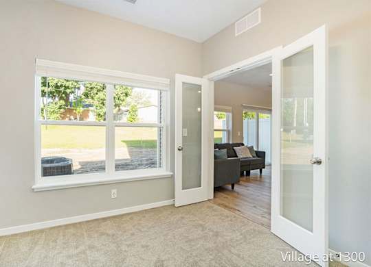 A room with a large window and a view of a backyard.