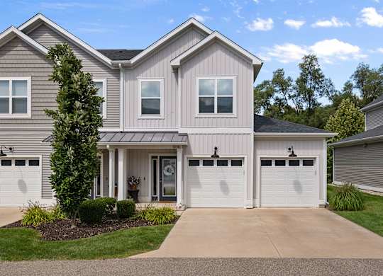 A two-story house with a garage and a driveway.