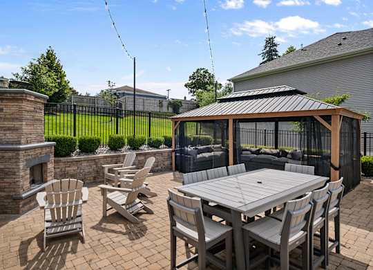 A patio with a table and chairs and a fireplace.