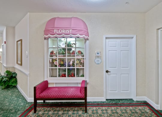 a flower shop with a pink awning and a red benchat Arbor Oaks at Greenacres, Greenacres, FL 33467