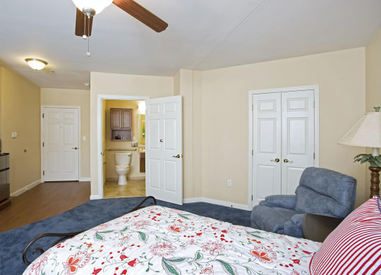 a bedroom with a bed and a chair at Arbor Oaks at Lakeland Hills, Lakeland, FL 33805