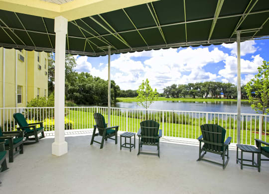 a patio with chairs and a table and a lake in the backgroundat Arbor Oaks at Lakeland Hills, Florida, 33805