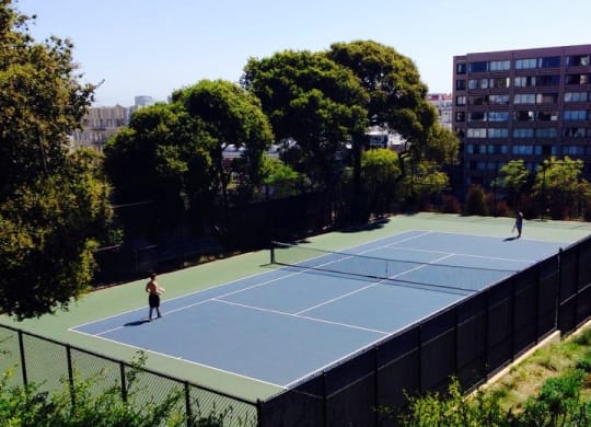 a couple of people playing tennis on a tennis court