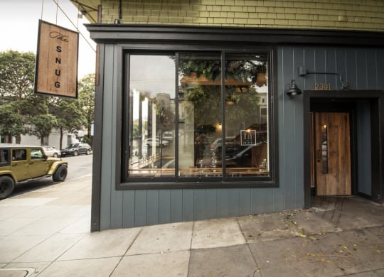 a storefront with a large window and a wooden door