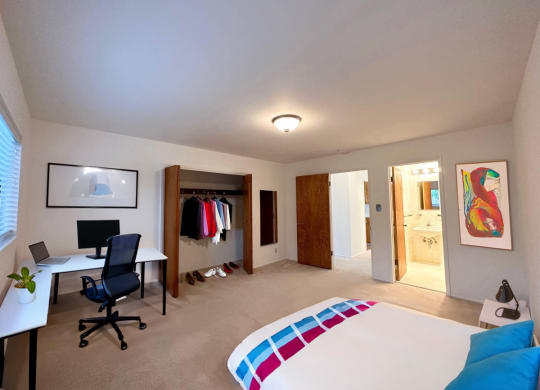 a bedroom with a bed and a desk in a room