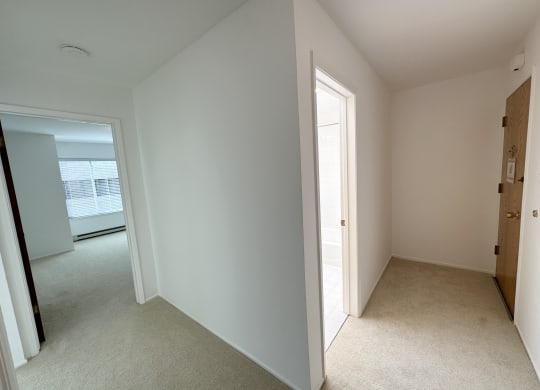 a bedroom with white walls and carpet
