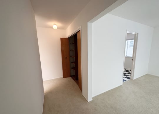 a view from the top of the stairs of a bedroom in a house with white walls and