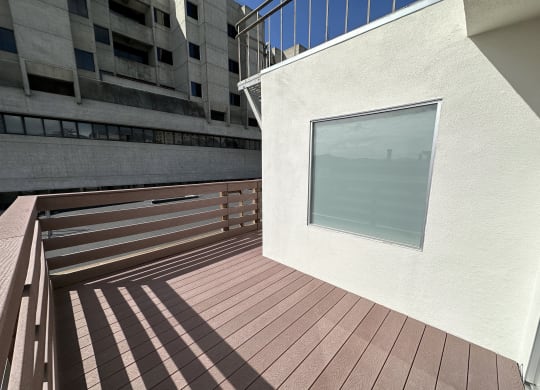 a large window in a white wall with a wooden deck