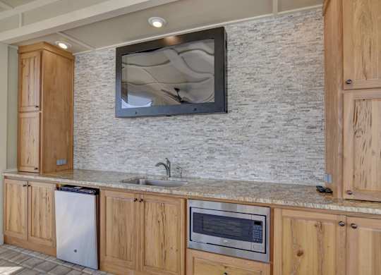 A kitchen with wooden cabinets and a granite countertop.