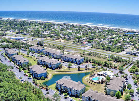 A bird's eye view of a residential area with a large body of water in the background.