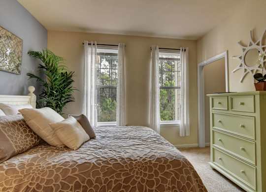 A bedroom with a large bed and a green dresser.
