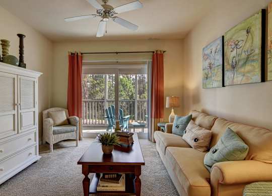 A living room with a couch, chair, and a table with a plant on it.