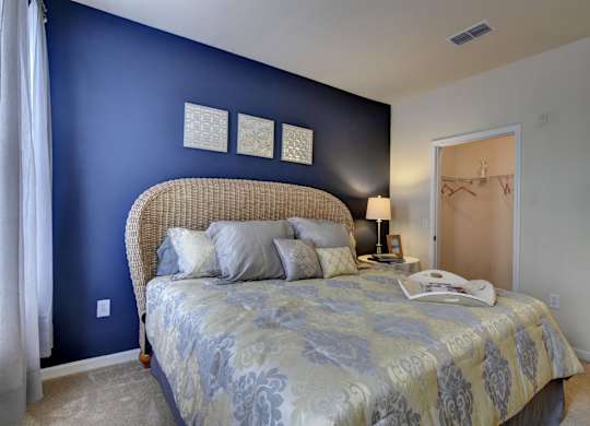 A bedroom with a bed and a lamp.