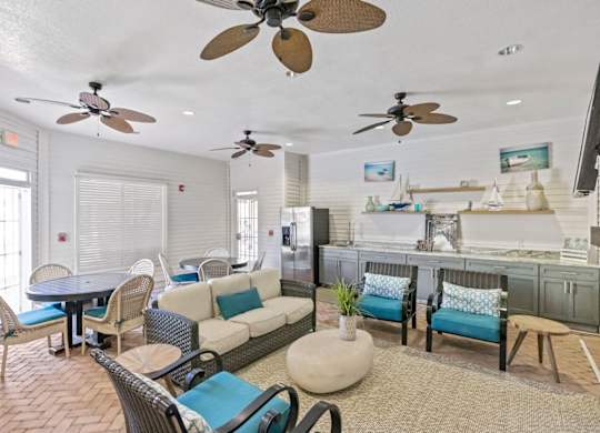 A living room with a couch, chairs, and a ceiling fan.