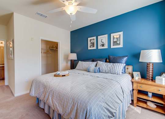 A bedroom with a bed, nightstand, and lamp.