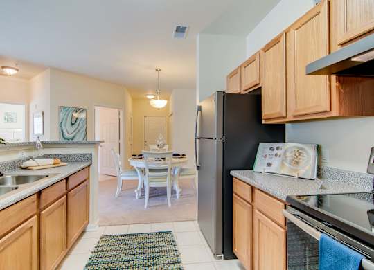 A kitchen with wooden cabinets and a black refrigerator.