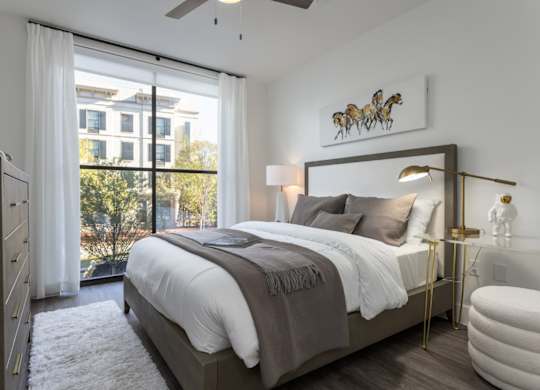 modern bedroom with natural light, ceiling fan, and wood plank flooring at 2020 Providence in Huntsville, AL