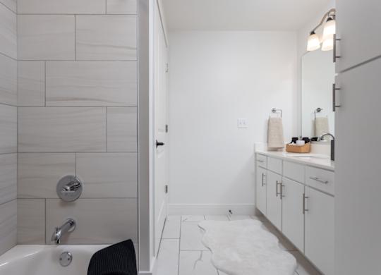 En-suite bathroom with double vanity, premium fixtures, and tile tub/shower surround at 2020 Providence in Huntsville, AL