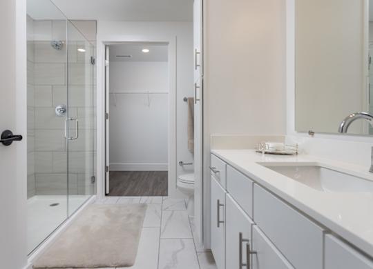 Primary bathroom with modern glass stand-alone shower and quartz countertops at 2020 Providence in Huntsville, AL