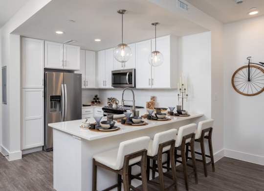 A modern kitchen with a white island and dark wood floors at 2020 Providence in Huntsville, AL