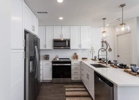 A modern kitchen with white cabinets and stainless-appliances at 2020 Providence in Huntsville, AL