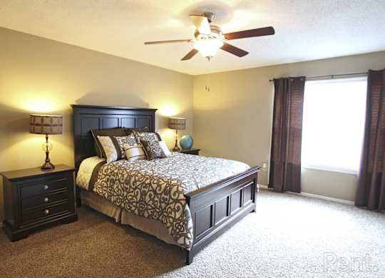 A bedroom with a large bed and a ceiling fan at The Oakley at Hillcrest in Mobile, AL