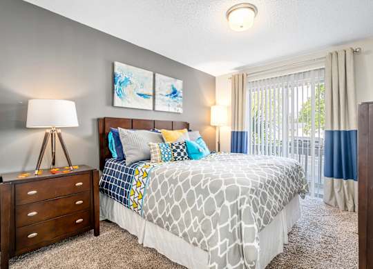 spacious primary bedroom with direct access to private patio or balcony at 701 South Apartments in Mobile, AL