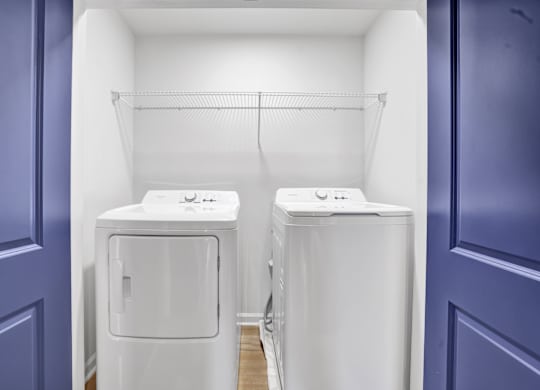 two washing machines in a room with a blue door