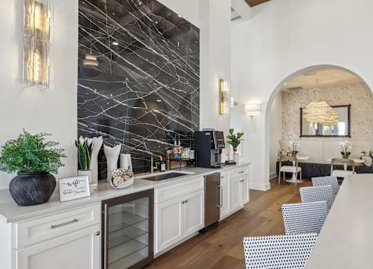 A kitchen with a white counter top and a black vase.