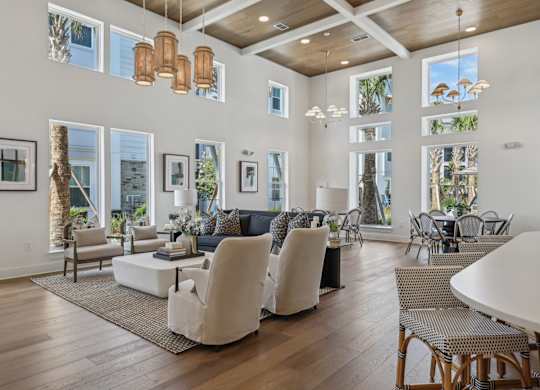 A living room with a white couch and chairs.