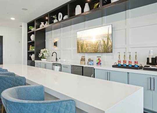 Clubhouse kitchen with large island, full kitchen, and TV at Tapestry University Park in Sarasota, FL