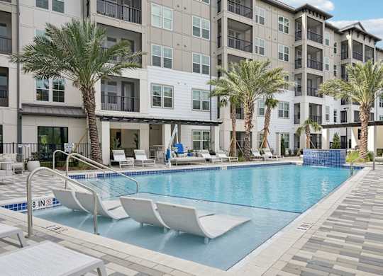 Swimming pool with tanning shelf at Tapestry University Park Apartments in Sarasota, FL