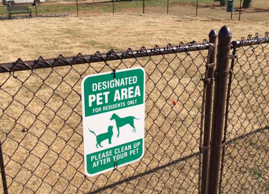 A sign on a fence designates the area as a pet-only zone.