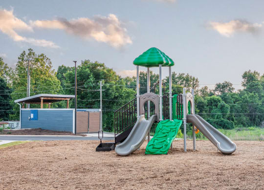 a playground with two slides and a jungle gym  at Anthem Apartments and Cottages in Huntsville, Alabama