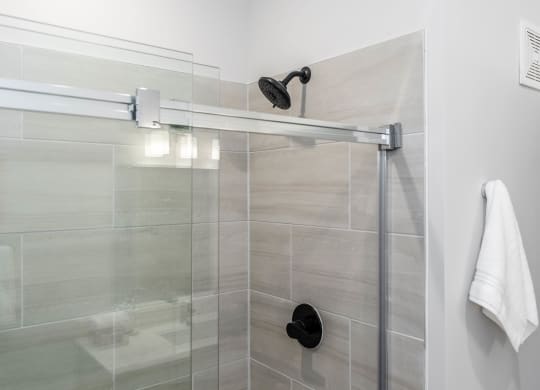 shower with sliding glass door and modern fixtures at Anthem Apartments and Cottages in Huntsville, Alabama