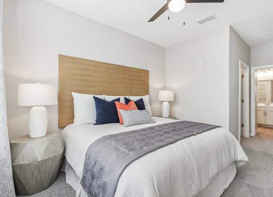 a bedroom with a large bed and a ceiling fan