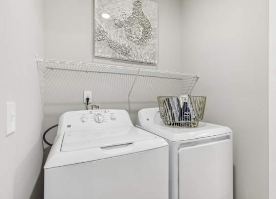a white washer and dryer in a white laundry room