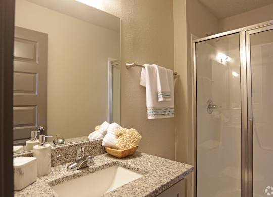 Bathroom with stand-alone shower and granite countertops at Avia Apartments in Vestavia Hills, AL