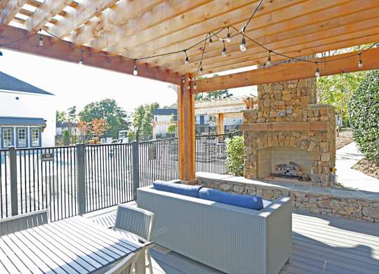 A wooden deck with a bench and a fireplace at Avia Apartments in Vestavia Hills, AL