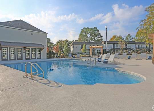 Sparkling pool with expansive sundeck and chaise lounges at Avia Apartments in Vestavia Hills, AL
